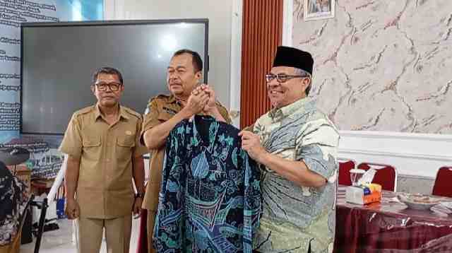 Ketua DPRD Provinsi Sumatera Barat, Muhidi menyerahkan secara simbolis stelan batik kepada Kepala SMAN 10 Padang, Muhammad Isya.